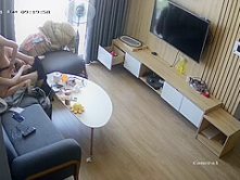 Young couple in livingroom, riding on sofa