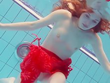 Red Dressed teen swimming with her eyes opened